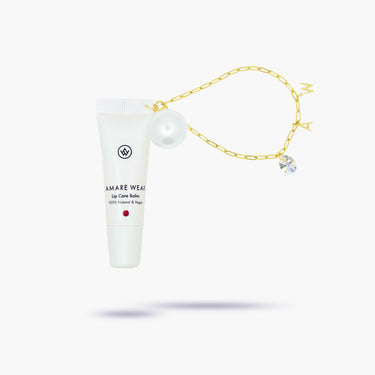 White lip balm tube with gold chain and decorative elements on a white background